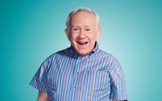 an older man wearing a blue and red striped shirt with his hands in his pockets