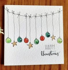 a christmas card with ornaments hanging from strings