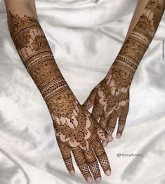 two hands with henna tattoos on them