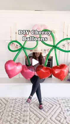 a woman holding balloons in front of a fireplace with the words diy cherry balloons