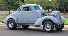 an old car is parked on the side of the road