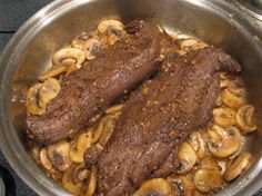 steak and mushrooms cooking in a pan on the stove