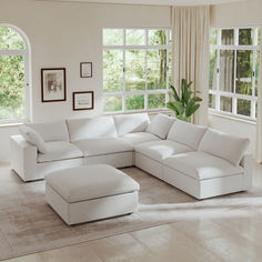 a living room with white furniture and large windows