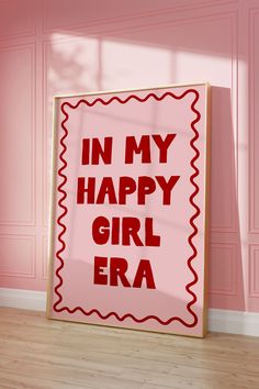 a red and white sign that says in my happy girl era on the side of a pink wall