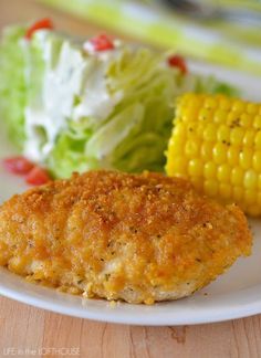 a white plate topped with chicken patties next to a corn on the cob