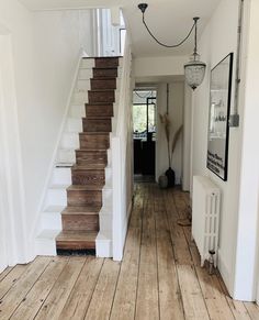 a hallway with wooden floors and white walls