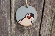 a wooden ornament with a penguin painted on it