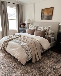 a bedroom with a bed, dresser and window