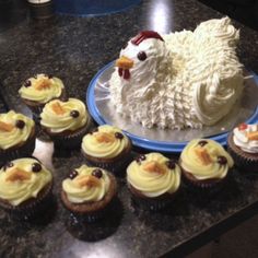 cupcakes with frosting and icing are arranged on a counter next to a cake