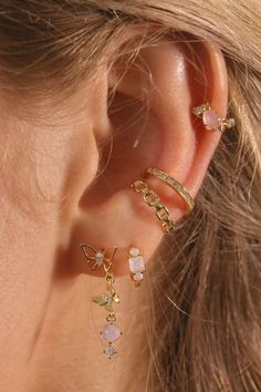 a woman wearing three different types of ear piercings