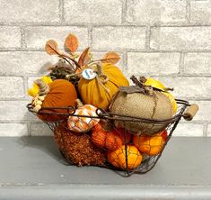 a basket filled with pumpkins and gourds sitting on top of a table