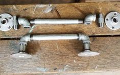 two metal pipe holders on top of a wooden table