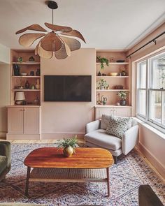 a living room with a couch, coffee table and ceiling fan in the middle of it