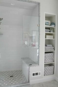 a bathroom with white walls and tile flooring next to a walk - in shower