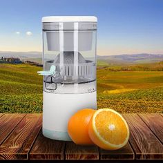 an orange sitting next to a juicer on top of a wooden table in front of a field