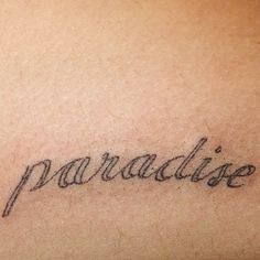 the word paradise written in cursive writing on someone's back