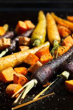 roasted root vegetables on a grill with text overlay reading sea salt, rosemary & thy roasted root vegetables