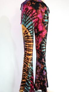 "These tie dye splatter bell bottoms are made for movement! Perfect for yoga and flow activities. Handmade and hand-dyed, 🌈 The fitting around the thigh is flattering & shaping until the material billows out at the knee into a wide flare.  Featuring drawstrings on either side of the thigh that can be cinched for shape and length adjustment! The material consists of a quality cotton Lycra blend; cotton giving ultra softness while Lycra holds everything in.  95% Cotton 5% Lycra (highly *◅ ↠ ॐ ☽ ◅ Fitted Hippie Flares For Summer, Hippie Wide Leg Flares For Summer, Hippie Style Wide Leg Summer Flares, Summer Hippie Wide Leg Flares, Hippie Wide Leg Summer Flares, Tie Dye Bottoms For Festivals, Hand Dyed Tie Dye Bottoms For Festival, Festival Tie-dye Hand Dyed Bottoms, Festival Tie-dye Hand-dyed Bottoms