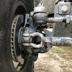 the front wheel of a truck with rust on it's rims and gears