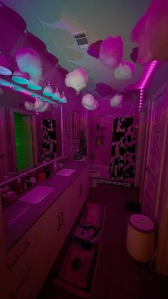 a bathroom with pink lighting and decorations on the ceiling