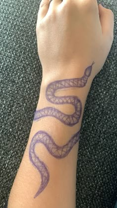 a person's arm with a purple snake tattoo on it