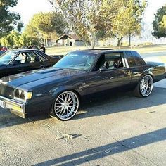 a black car parked in a parking lot next to other cars