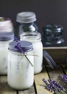 three jars filled with lavender sitting on top of a wooden table