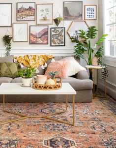 a living room filled with furniture and lots of pictures on the wall above it's coffee table