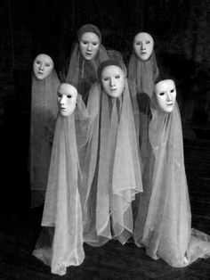 a group of mannequins with veils on their heads in front of a black and white photo