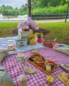 a picnic table with food on it and balloons in the air above them, along with other items