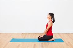 a woman is sitting on a yoga mat in the middle of a room