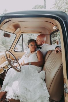 a bride and groom sitting in the back of an old truck together for their wedding photo