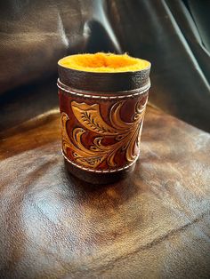 a brown leather cup holder with yellow felt inside