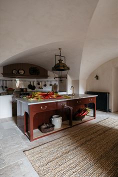 a large kitchen with an island in the middle and lots of food on the counter