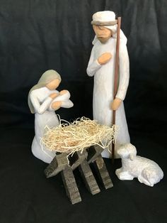 a nativity scene with two figurines and a baby jesus in the manger