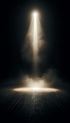 an empty room with light coming from the ceiling and fog in the air on the floor