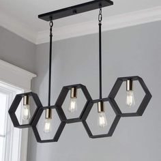 a light fixture with five lights hanging from it's center and hexagonal shapes