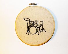 a drum kit embroidered onto a wooden hoop