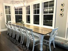 a dining room table and chairs with windows in the back ground, and hardwood flooring on the other side