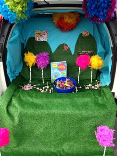 the trunk of a car decorated with pom poms and decorations for children's birthday