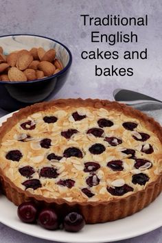 there is a pie on the plate with cherries and almonds next to it