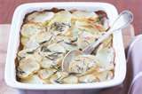 a casserole dish with potatoes and herbs in it is ready to be eaten