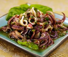 an octopus salad is served on a blue plate