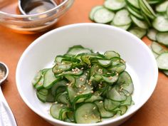 a white bowl filled with cucumbers and sesame seeds