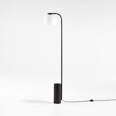 a black floor lamp with a white light on the top and an electric cord attached to it