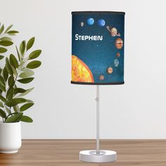 a lamp with the name stephen on it next to a potted plant