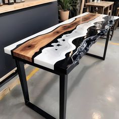 the table is made out of wood and has black metal legs with white marble on it