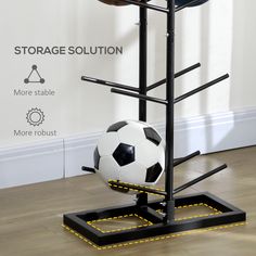 a soccer ball sitting on top of a black stand next to a white and yellow wall