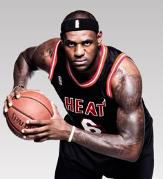 a man holding a basketball in his right hand and wearing a head band on top of it