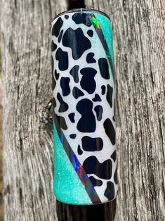 a close up of a bottle on a wooden surface with a tree in the background